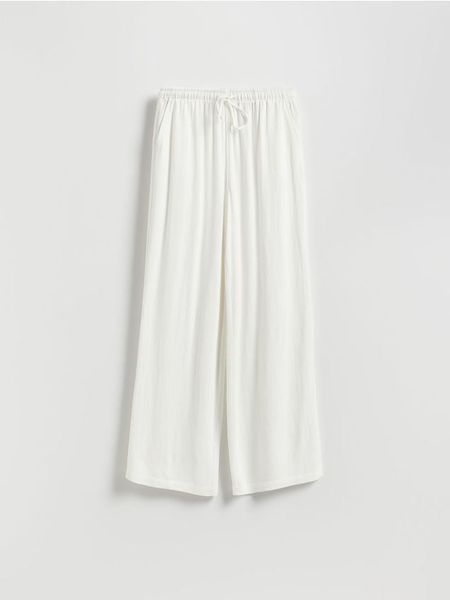 Luźne spodnie z domieszką lnu - złamana biel. Spodnie materiałowe damskie Reserved, l, bez wzorów, z tkaniny. Za 99.99 zł.