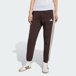 Spodnie Stadium Three Stripes Regular. Brązowe spodnie materiałowe damskie Adidas, l, bez wzorów, z bawełny, z standardowym stanem. Za 279.00 zł.