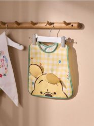 Śliniak Winnie the Pooh - żółty. Żółte śliniaki dla dzieci Sinsay, bez wzorów. Za 12.99 zł.