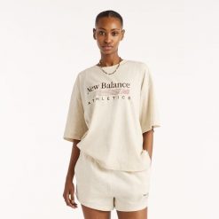 Koszulka damska New Balance WT6297MKLIT – beżowa. Brązowe koszulki sportowe damskie New Balance, s, bez wzorów, z materiału, eleganckie, bez kołnierzyka. Za 179.99 zł.