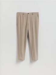 Garniturowe spodnie carrot - beżowy. Brązowe spodnie materiałowe męskie Reserved, bez wzorów, z tkaniny. Za 169.99 zł.