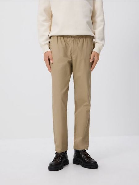 Spodnie jogger slim - beżowy. Brązowe spodnie materiałowe męskie Reserved, l, bez wzorów, z bawełny. W wyprzedaży za 39.99 zł.