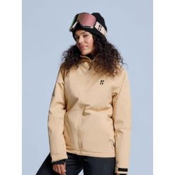 Kurtka narciarska damska - Arctic 2L ocieplana - ciepły piasek. Brązowe kurtki snowboardowe damskie POEDERBAAS, l, bez wzorów, z poliesteru, bez kaptura, narciarskie. W wyprzedaży za 807.02 zł.