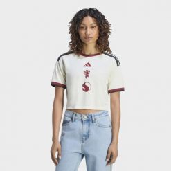 Koszulka z trzeciego zestawu Manchester United 26/27 o skróconym fasonie. Białe koszulki sportowe damskie Adidas, m, bez wzorów, z materiału, bez kołnierzyka, bez ramiączek, do piłki nożnej, climacool (adidas). Za 369.00 zł.