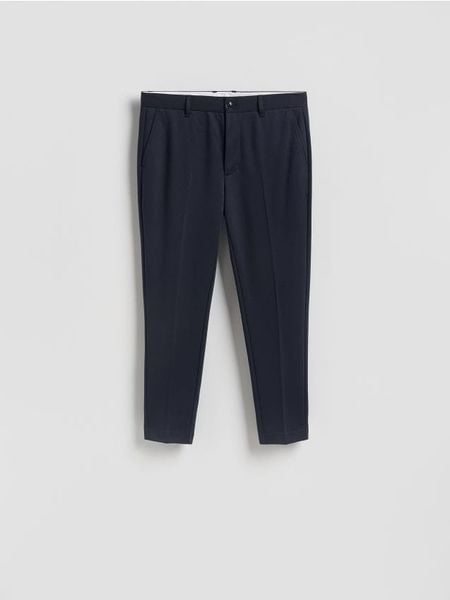 Spodnie chino slim fit - granatowy. Niebieskie spodnie materiałowe męskie Reserved, l, bez wzorów, z dzianiny. Za 139.99 zł.