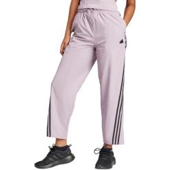 Spodnie damskie adidas Future Icons Three Stripes Woven. Czerwone obuwie sportowe damskie Adidas, bez wzorów, z materiału, na fitness i siłownię. Za 229.99 zł.