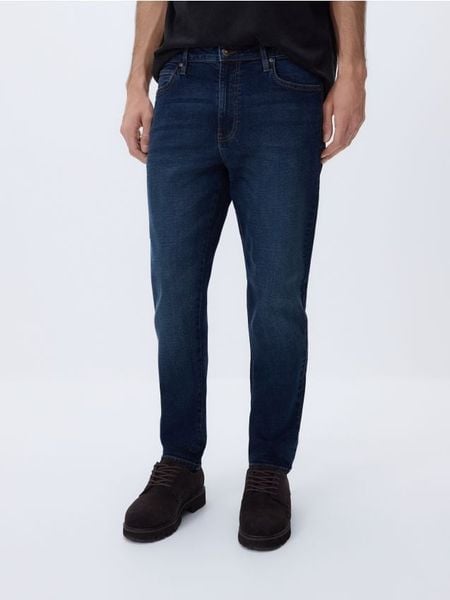 Jeansy carrot slim z efektem sprania - granatowy. Niebieskie jeansy męskie Reserved. Za 129.99 zł.