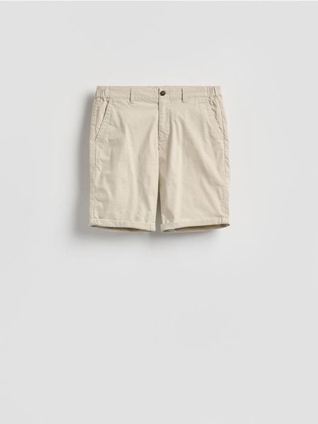 Bawełniane szorty chino - beżowy. Brązowe spodnie materiałowe męskie Reserved, l, bez wzorów, z bawełny. Za 119.99 zł.