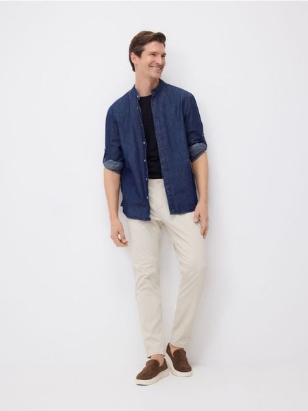 Spodnie chino slim fit - kremowy. Białe spodnie materiałowe męskie Reserved, bez wzorów, z bawełny. Za 109.99 zł.