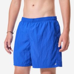 Szorty pływackie dla dzieci Nabaiji Swimshort. Niebieskie kąpielówki dla chłopców Decathlon, bez wzorów, z materiału, sportowe. Za 39.99 zł.