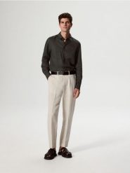 Spodnie chino z dodatkiem lnu - beżowy. Brązowe spodnie materiałowe męskie Reserved, bez wzorów, z bawełny. W wyprzedaży za 129.99 zł.