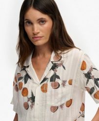 Superdry Koszula damska Beach Printed z bawełny i wiskozy – Citrus Cream Print. Białe koszule damskie Superdry., na lato, bez wzorów, z bawełny, klasyczne, bez kołnierzyka, bez ramiączek. Za 219.45 zł.