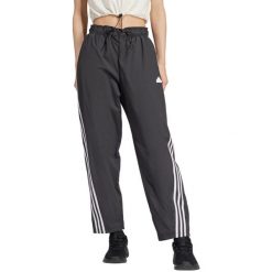 Spodnie damskie adidas Future Icons Three Stripes Woven. Czarne obuwie sportowe damskie Adidas, bez wzorów, z poliesteru, na fitness i siłownię. Za 229.99 zł.