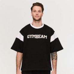 Koszulka męska oversize czarna Varsity Premium Heavyweight. Czarne koszulki sportowe męskie GYMBEAM, m, bez wzorów, z bawełny, bez kołnierzyka, bez ramiączek, na fitness i siłownię. Za 113.90 zł.