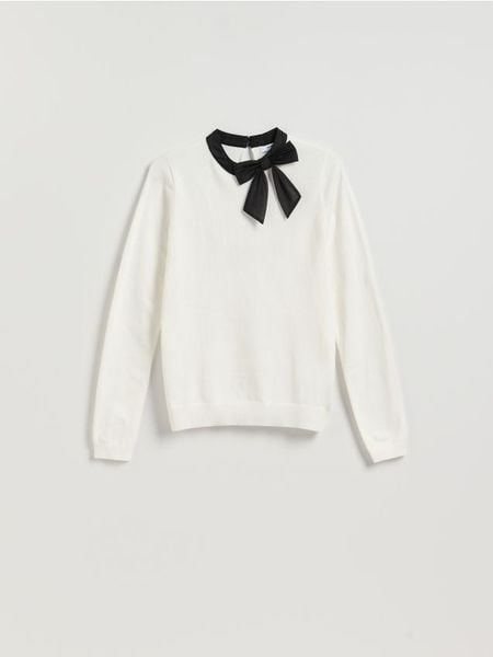 Sweter z ozdobną kokardą - kremowy. Białe swetry damskie Reserved, l, bez wzorów, z dzianiny, bez kołnierzyka, bez ramiączek, bez kaptura. Za 109.99 zł.