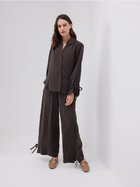 Szerokie spodnie z modalem - ciemnobrązowy. Brązowe spodnie materiałowe damskie Reserved, l, bez wzorów, z tkaniny. W wyprzedaży za 59.99 zł.