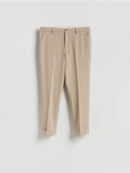 Garniturowe spodnie carrot - beżowy. Brązowe eleganckie spodnie męskie Reserved, bez wzorów, z tkaniny. Za 169.99 zł.
