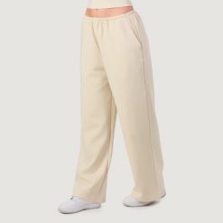 Spodnie damskie fitness oversize z kieszeniami migdałowe NEO. Brązowe spodnie dresowe damskie GYMBEAM, l, bez wzorów, z dresówki. Za 132.90 zł.