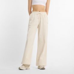 Spodnie damskie New Balance WP51503LIN – beżowe. Brązowe spodnie materiałowe damskie New Balance, l, z aplikacjami, z bawełny. Za 359.99 zł.