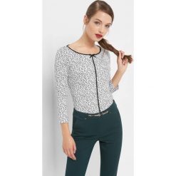 Koszulka w kwiaty z lamówką. Białe bluzki damskie Orsay, w kwiaty, z bawełny, z kokardą. Za 69.99 zł.