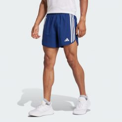 Szorty Own the Run 3-Stripes. Niebieskie krótkie spodenki sportowe męskie Adidas, bez wzorów, z materiału, do biegania. Za 229.00 zł.