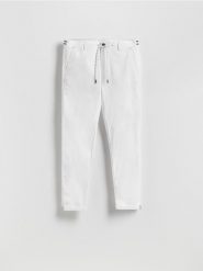 Bawełniane spodnie chino slim - biały. Białe spodnie materiałowe męskie Reserved, l, bez wzorów, z bawełny. Za 139.99 zł.