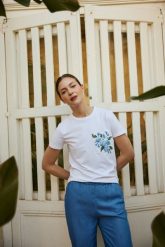 Bluzka z kieszonką i nadrukiem biała. Białe bluzki damskie MOODO, l, bez wzorów, z bawełny, bez kołnierzyka, bez ramiączek. Za 59.99 zł.