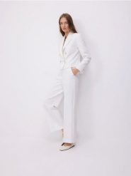 Szerokie spodnie z dekoracyjnymi guzikami - złamana biel. Spodnie materiałowe damskie Reserved, l, bez wzorów, z tkaniny. W wyprzedaży za 119.99 zł.