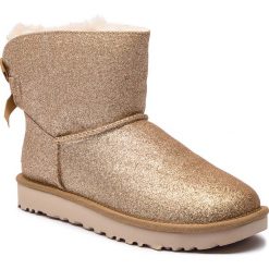 Buty UGG - W Mini Bailey Bow Sparkle 1100053 W/Gold. Kozaki damskie marki UGG. W wyprzedaży za 569.00 zł.