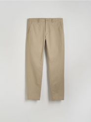 Bawełniane spodnie chino slim - beżowy. Brązowe spodnie materiałowe męskie Reserved, bez wzorów, z bawełny. Za 159.99 zł.