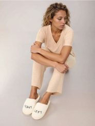 Kapcie ze sztucznym futerkiem i haftowanym napisem - kremowy. Białe kapcie damskie Sinsay, bez wzorów. Za 19.99 zł.