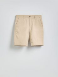 Szorty chino regular fit - beżowy. Brązowe spodnie materiałowe męskie Reserved, bez wzorów, z bawełny. Za 119.99 zł.
