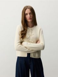 Kardigan z kokardami - kremowy. Białe kardigany damskie Reserved, l, bez wzorów, z dzianiny. W wyprzedaży za 119.99 zł.