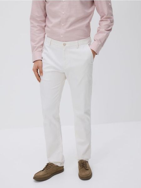 Spodnie chino slim - biały. Białe spodnie materiałowe męskie Reserved, bez wzorów, z bawełny. Za 159.99 zł.