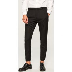 Spodnie carrot fit na kant - Czarny. Eleganckie spodnie męskie marki Giacomo Conti. W wyprzedaży za 99.99 zł.