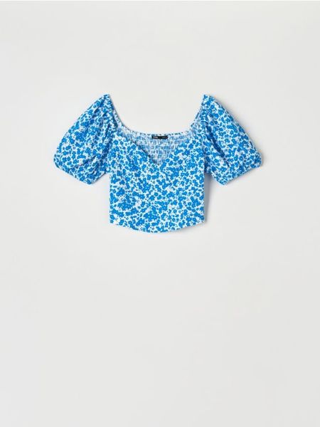 Bluzka w kwiaty - niebieski. Niebieskie bluzki damskie Sinsay, l, bez wzorów, bez kołnierzyka, bez ramiączek. Za 35.99 zł.