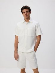 Szorty regular fit - złamana biel. Szorty męskie Reserved, l, bez wzorów, z bawełny. Za 99.99 zł.