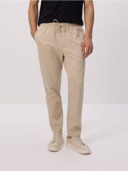 Spodnie regular fit - złamana biel. Spodnie materiałowe męskie Reserved, l, bez wzorów, z dzianiny. W wyprzedaży za 89.99 zł.