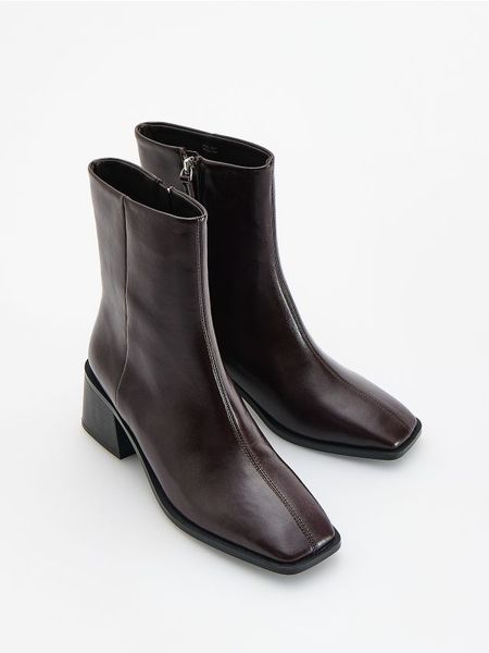 Skórzane botki - mahoniowy. Brązowe botki damskie Reserved, ze skóry, bez obcasa, bez zapięcia. Za 259.99 zł.