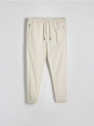 Spodnie jogger slim - złamana biel. Spodnie materiałowe męskie Reserved, l, bez wzorów, z bawełny. W wyprzedaży za 89.99 zł.