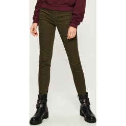 Spodnie slim z dziurami - Khaki. Spodnie materiałowe damskie marki Sinsay. W wyprzedaży za 39.99 zł.