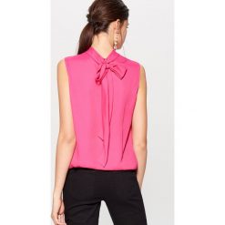 Elegancki top z wiązaniem na plecach - Różowy. Bluzki damskie marki Mohito, eleganckie, z dekoltem na plecach. W wyprzedaży za 59.99 zł.