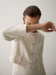 Krótki żakiet z tkaniny boucle - złamana biel. Żakiety damskie Reserved, l, bez wzorów, z bawełny. W wyprzedaży za 119.99 zł.