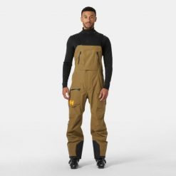 Kombinezon narciarski Helly Hansen Ridge Infinity. Brązowe spodnie sportowe męskie Helly Hansen, na zimę, m, bez wzorów, narciarskie. W wyprzedaży za 2,201.50 zł.