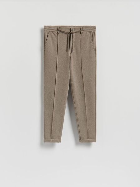 Spodnie chino slim - beżowy. Brązowe spodnie materiałowe męskie Reserved, l, bez wzorów, z dzianiny. W wyprzedaży za 79.99 zł.