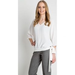 Bluzka w kolorze ecru z ozdobnym wiązaniem u dołu BIALCON. Białe bluzki damskie BIALCON, eleganckie, z dekoltem w serek. Za 179.00 zł.