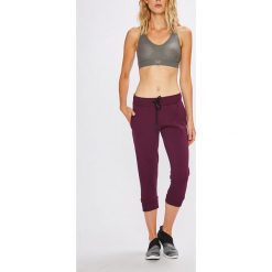Under Armour - Spodnie. Szare spodnie sportowe damskie Under Armour, z aplikacjami, z bawełny. W wyprzedaży za 169.90 zł.