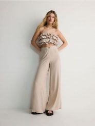 Szerokie spodnie - kremowy. Białe spodnie materiałowe damskie Reserved, l, bez wzorów, z tkaniny. W wyprzedaży za 49.99 zł.