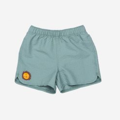 Szorty kąpielowe dla malucha Nabaiji Brom. Zielone szorty dla chłopców Decathlon, bez wzorów, z materiału, sportowe. Za 39.99 zł.