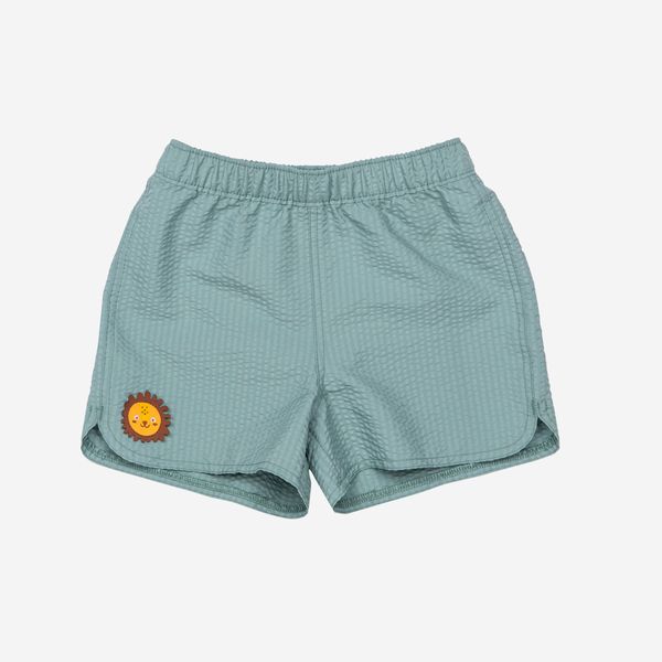 Szorty kąpielowe dla malucha Decathlon Brom. Zielone kąpielówki dla chłopców Decathlon, bez wzorów, z materiału. Za 39.99 zł.